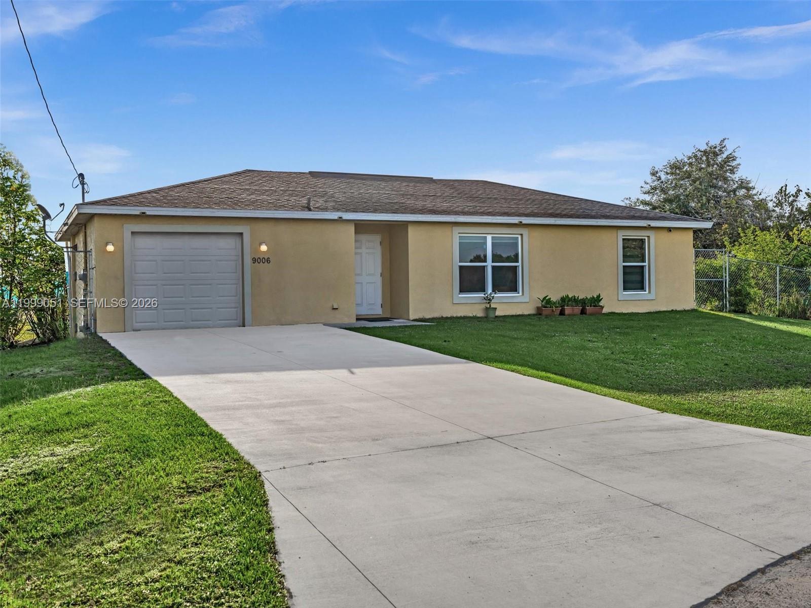 A single-story house with a tan stucco exterior, a one-car garage, and a concrete driveway — 9006 ABEL, La Belle FL 33935, LA BELLE, FL