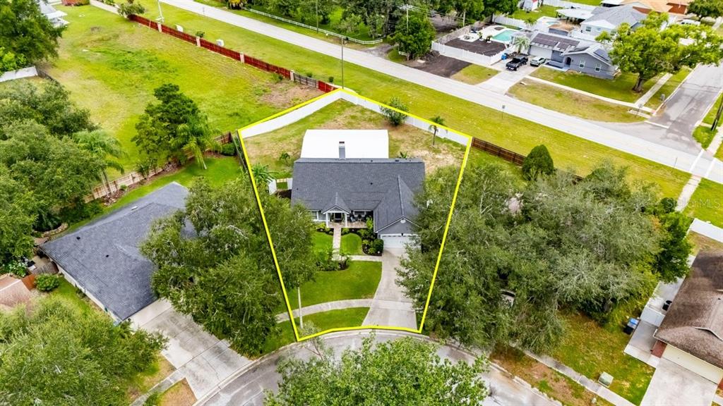 An aerial view shows a house with a dark roof on a corner lot — 829 GREENBELT CIRCLE, BRANDON, FL