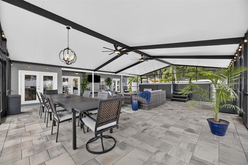 A spacious covered patio features a dining set, lounge furniture, and a hot tub — 829 GREENBELT CIRCLE, BRANDON, FL