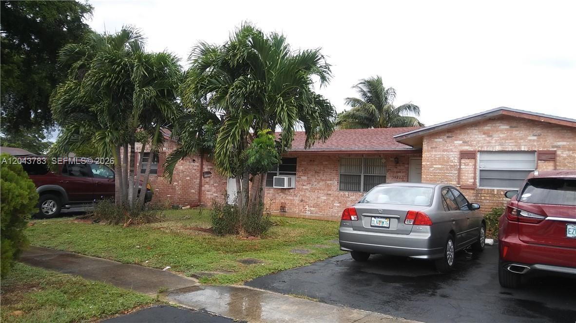 A single-story brick house features a driveway with two cars and several palm trees — 5425 NW 16th Ct # 0, Lauderhill FL 33313, LAUDERHILL, FL