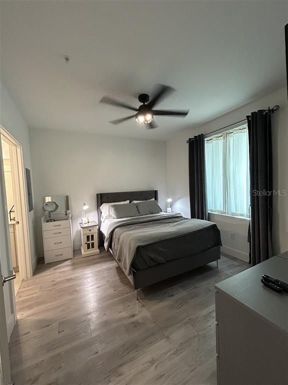 A bedroom features a bed, a small dresser, a vanity, and a ceiling fan — 1703 N TAMIAMI TRAIL UNIT 510, SARASOTA, FL