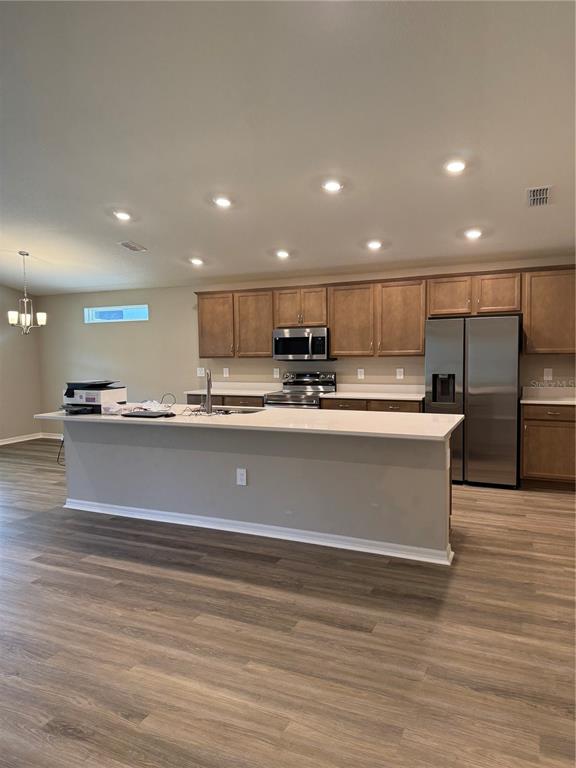 A kitchen features wood cabinets, stainless steel appliances, and a large white island countertop — 3902 WRENWOOD DRIVE, LAKELAND, FL