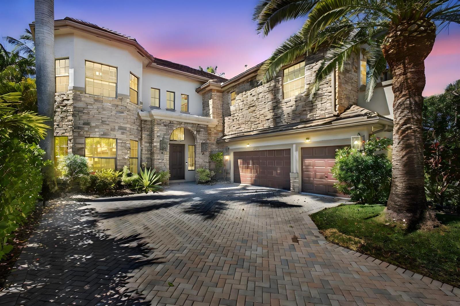 A two-story house with a stone facade, a paved driveway, and a large palm tree — 10468 Trianon Place, Wellington FL 33449, WELLINGTON, FL