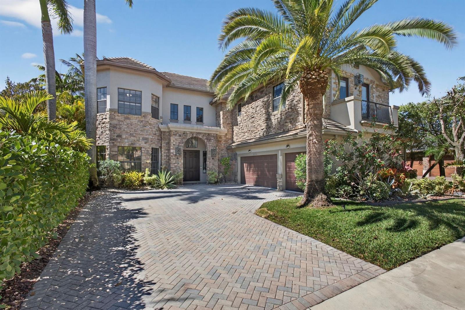A two-story house with a stone facade, a paved driveway, and a large palm tree — 10468 Trianon Place, Wellington FL 33449, WELLINGTON, FL