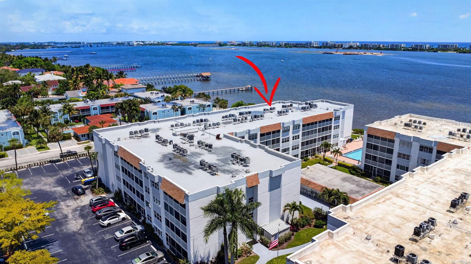 An aerial view shows a multi-story apartment building with a flat roof and parking lot — 1502 S Lakeside Drive # 214, FL 33460, FL