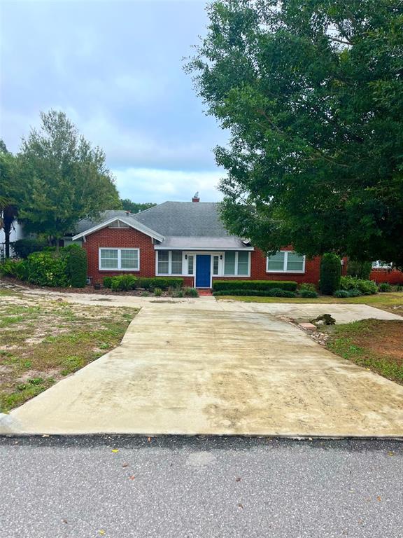 A single-story red brick house with a blue front door and a concrete driveway — 1200 W LAKE OTIS DRIVE SE, WINTER HAVEN, FL