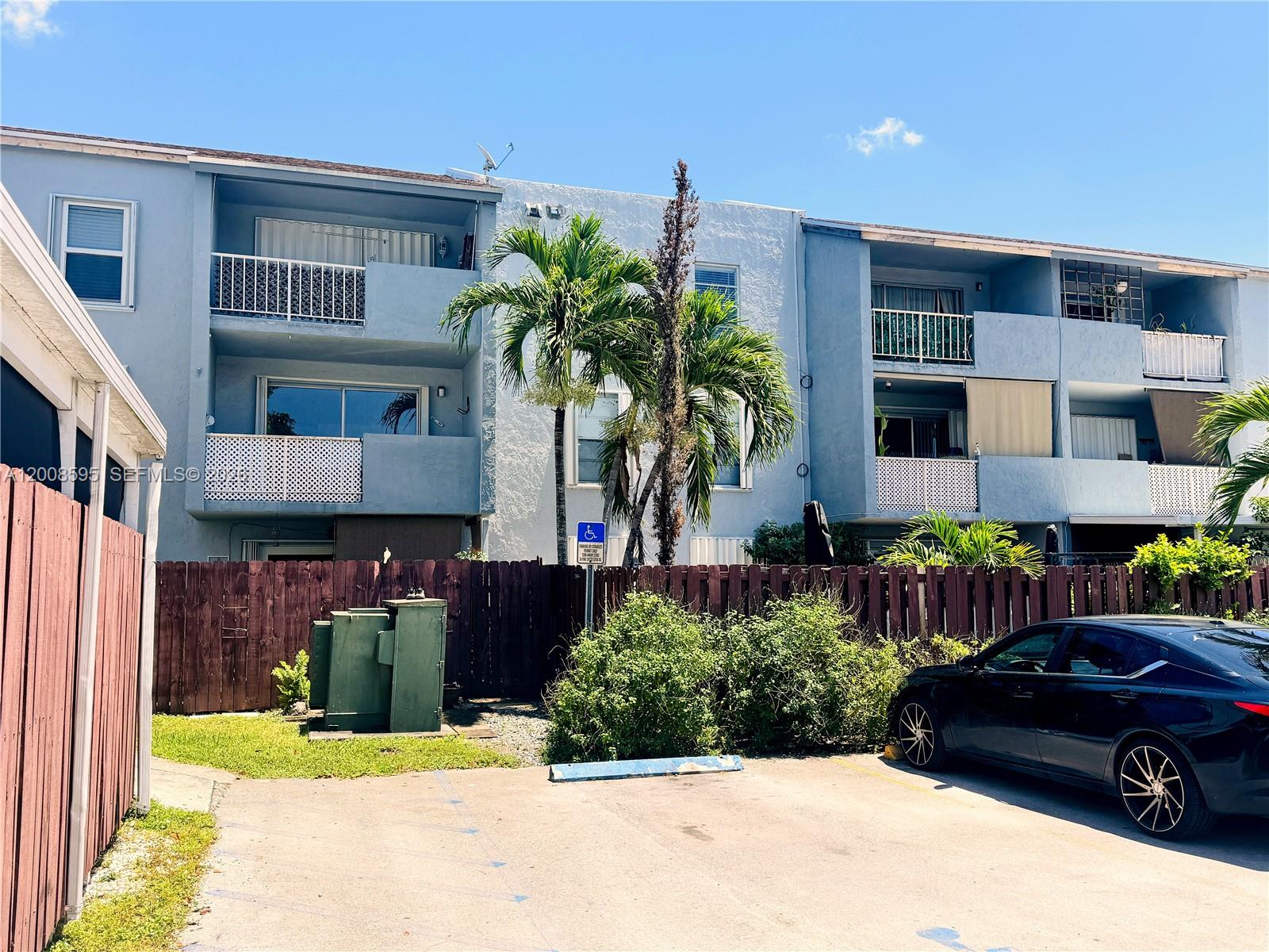 An exterior view of a multi-story apartment complex with a parking lot in front — 6095 W 18th Ave # S219, Hialeah FL 33012, HIALEAH, FL