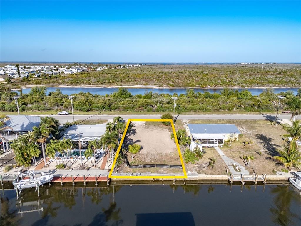 An aerial view shows a vacant waterfront lot outlined in yellow between two existing houses — 3314 YORK ROAD, ST JAMES CITY, FL
