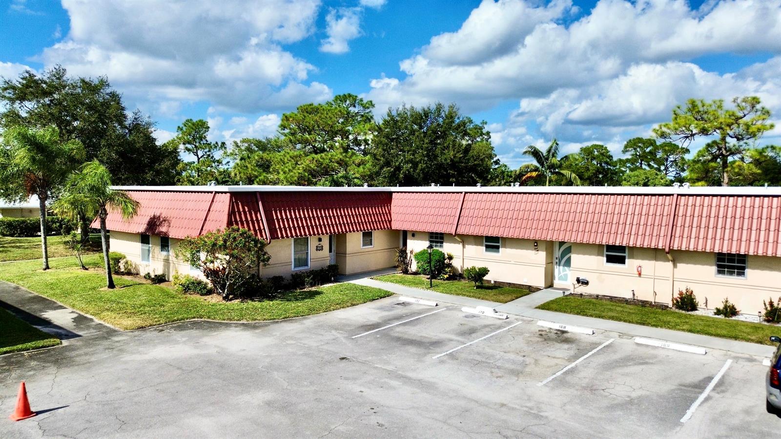 An aerial view of a single-story apartment building with a red tile roof and parking — 170 Amherst Lane, Lake Worth FL 33467, LAKE WORTH, FL
