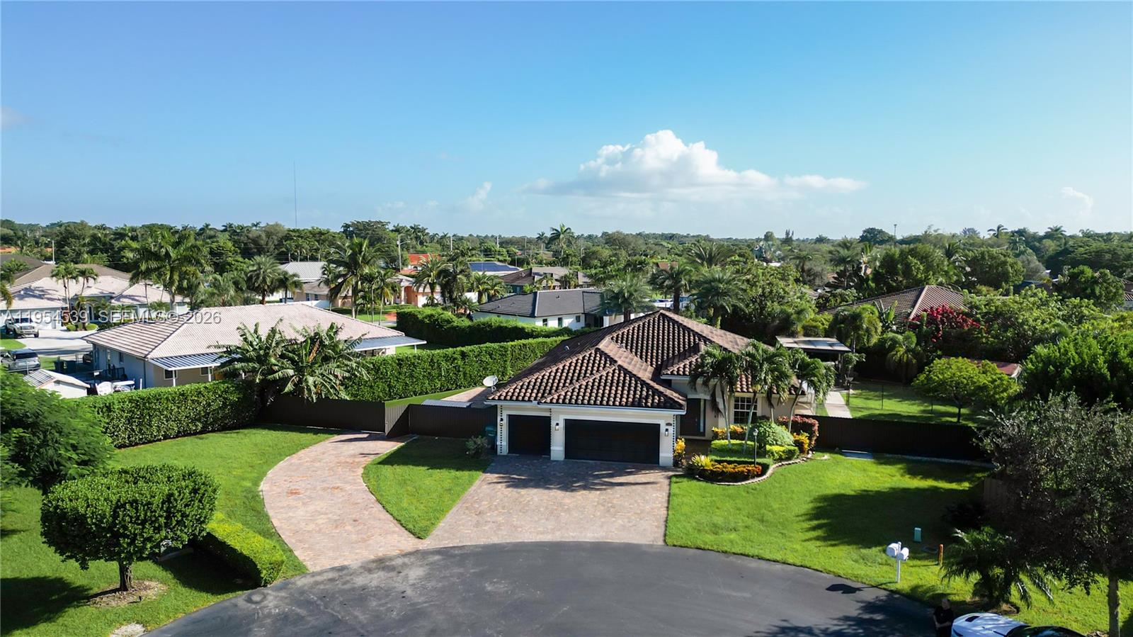 An aerial view shows a single-story house with a tiled roof and a paved driveway — 2133 NW 14th Pl, Homestead FL 33030, HOMESTEAD, FL