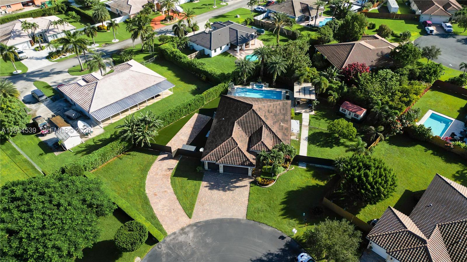 An aerial view shows a residential house with a tiled roof, pool, and paved driveway — 2133 NW 14th Pl, Homestead FL 33030, HOMESTEAD, FL