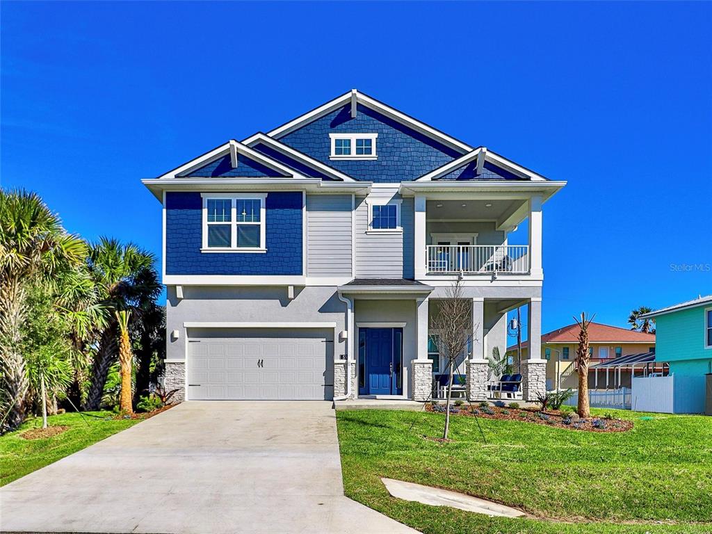 A two-story house with blue shingle siding, a gray garage, and a covered front balcony — 55 ATLANTIC DRIVE, PALM COAST, FL