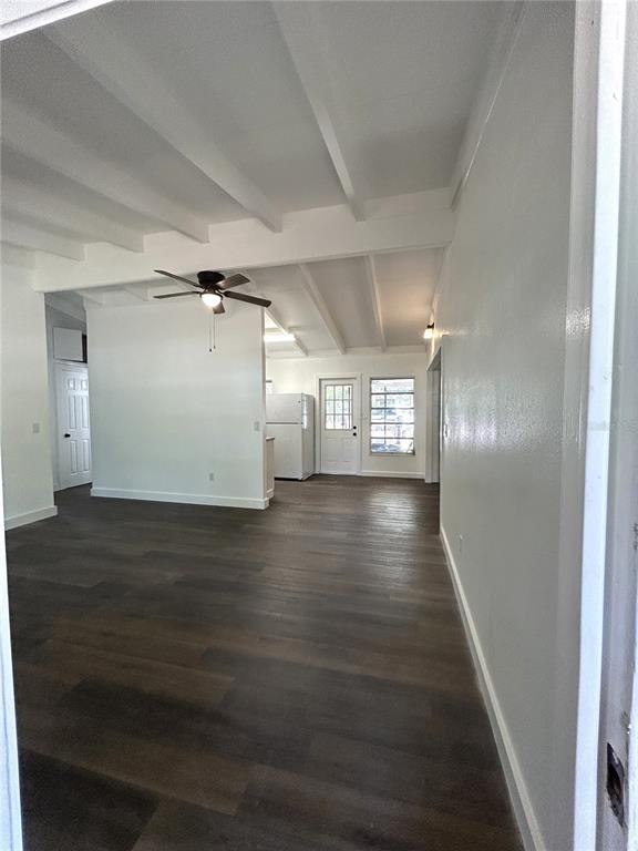 An open-concept living area features white vaulted ceilings, dark wood-look flooring, and a ceiling fan — 34798 EVERGREEN WAY, DADE CITY, FL