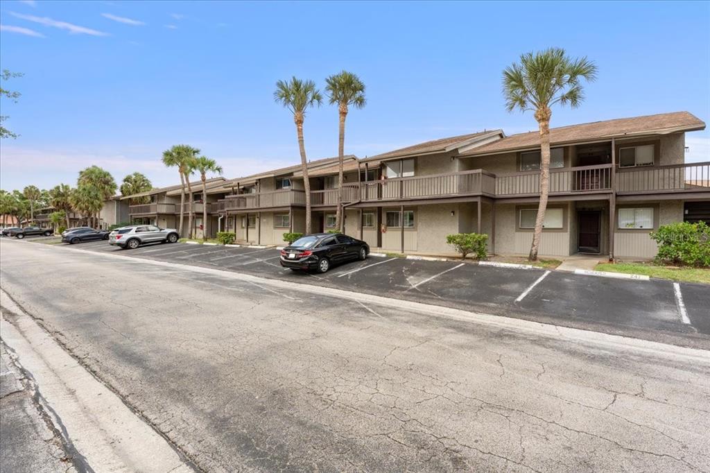 A two-story apartment building with a parking lot and palm trees in front — 6332 NEWTOWN CIRCLE UNIT 32B5, TAMPA, FL
