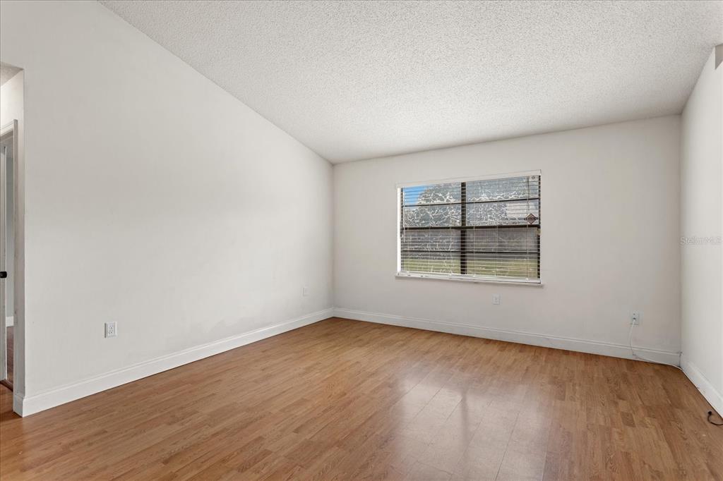 An empty room with white walls, wood-look flooring, and a single window with blinds — 5031 WATER WHEEL COURT, OCOEE, FL