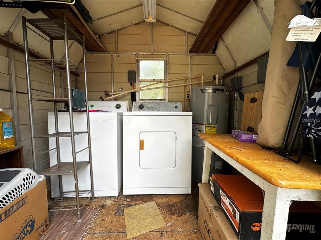 A utility shed contains a washer, dryer, water heater, and storage shelving — 12212 NE 238TH TERRACE, SALT SPRINGS, FL