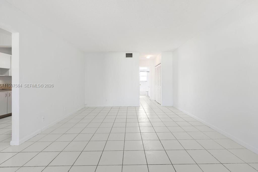 An empty room features white walls and light-colored square floor tiles — 500 NE 2nd St # 223, Dania Beach FL 33004, DANIA BEACH, FL