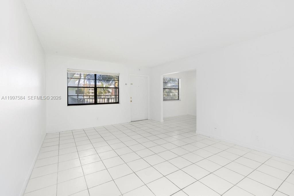 A bright, empty room features white walls, white tiled floors, and two windows — 500 NE 2nd St # 223, Dania Beach FL 33004, DANIA BEACH, FL