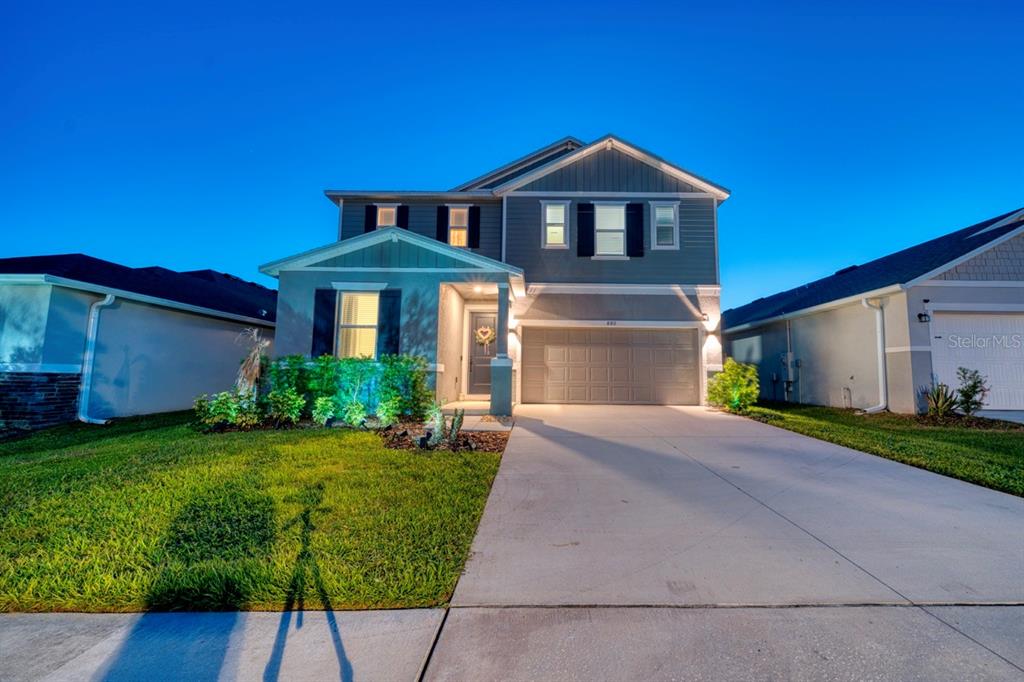 A two-story suburban house with a gray exterior, a two-car garage, and a front lawn — 880 ALVANLEY COURT, DAVENPORT, FL