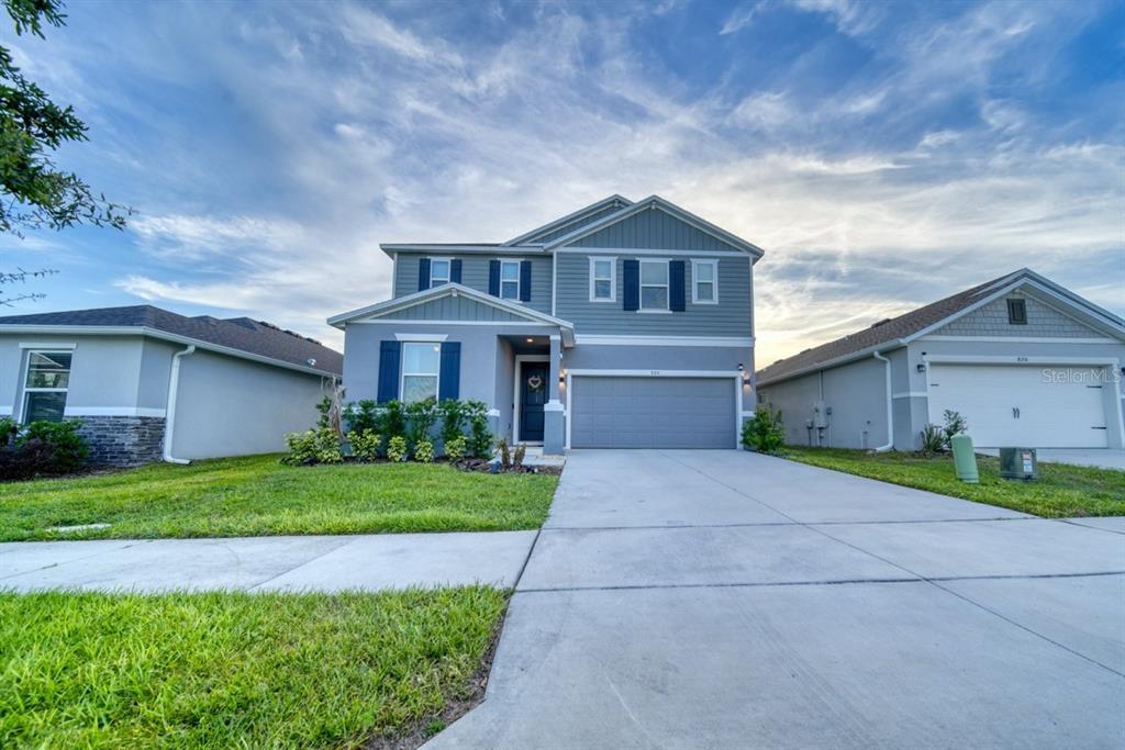 A two-story blue house with a two-car garage and a concrete driveway — 880 ALVANLEY COURT, DAVENPORT, FL