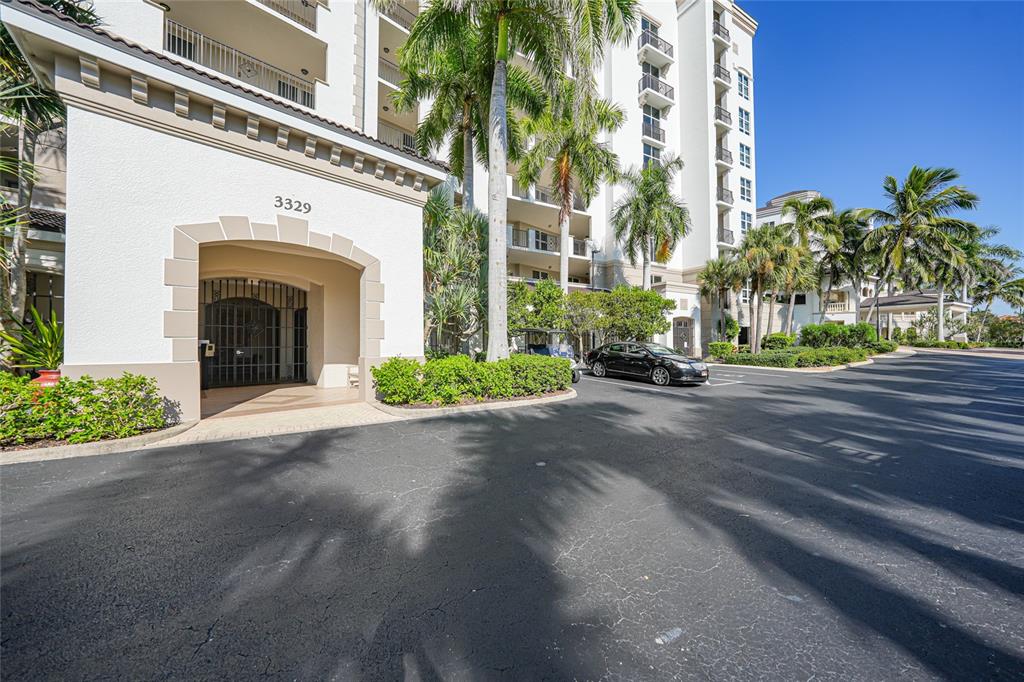 The exterior of a multi-story residential building features a covered entrance with the number 3329 — 3329 SUNSET KEY CIRCLE UNIT 308, PUNTA GORDA, FL