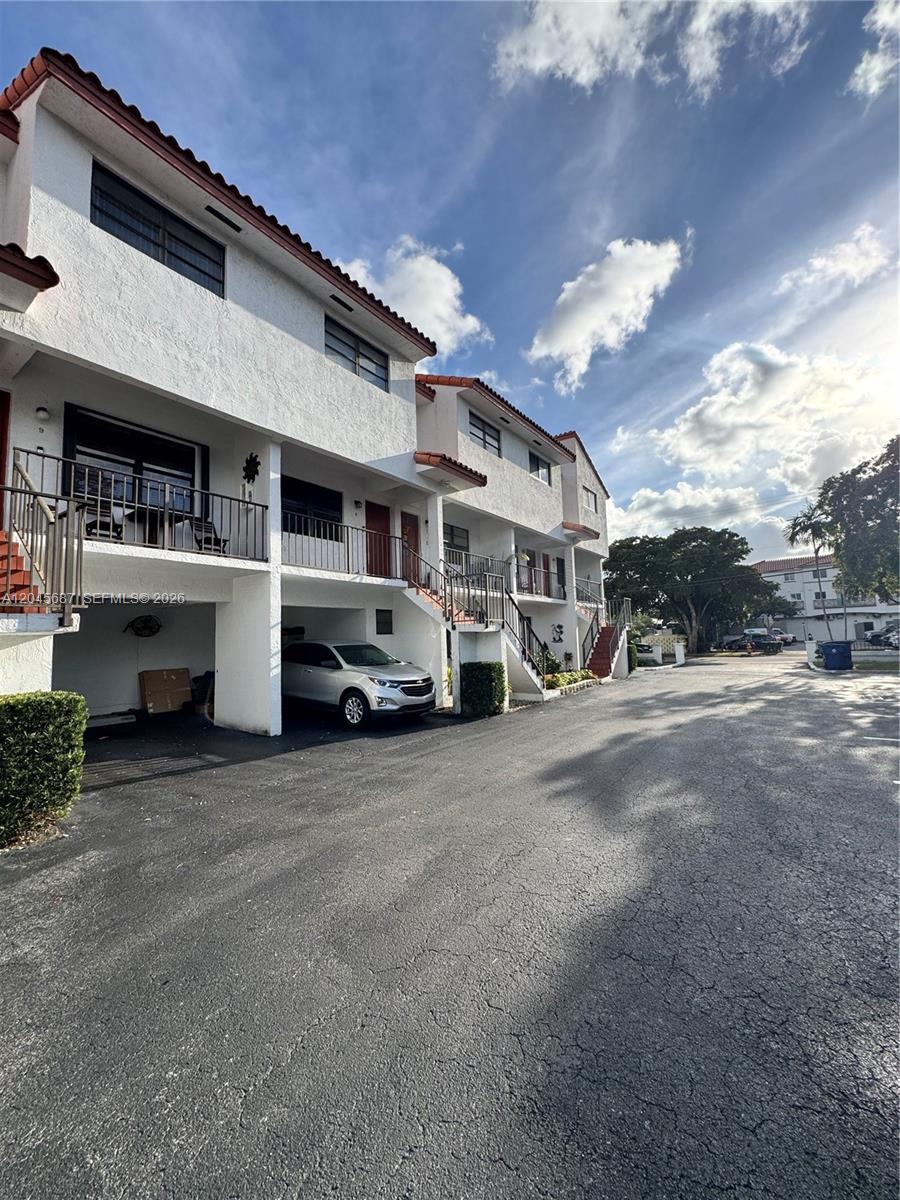 A multi-story residential building features white stucco walls, red tile roofs, and covered parking — 421 Swallow Dr # 10, Miami Springs FL 33166, MIAMI SPRINGS, FL