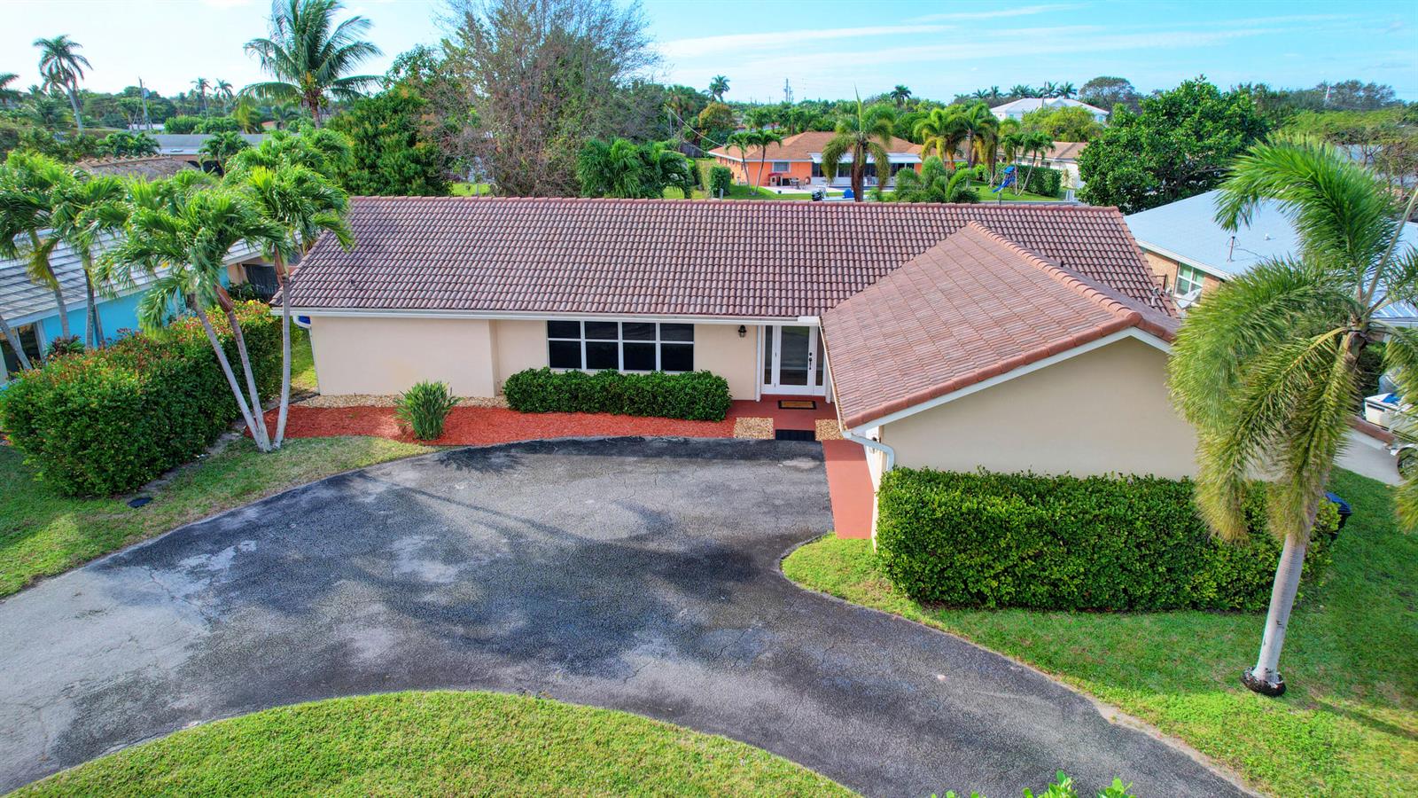 An aerial view of a single-story house with a tiled roof and a paved driveway — 1753 W Terrace Drive, FL 33460, FL