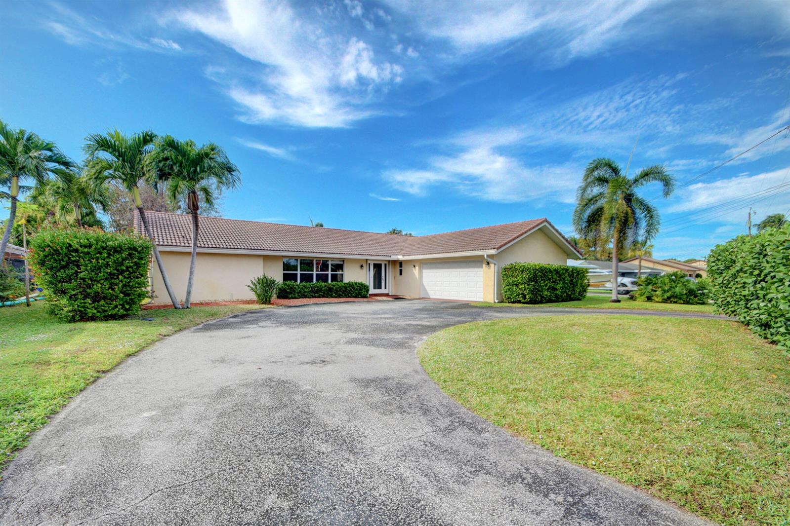 A single-story house with a beige exterior, a tiled roof, and a curved asphalt driveway — 1753 W Terrace Drive, FL 33460, FL