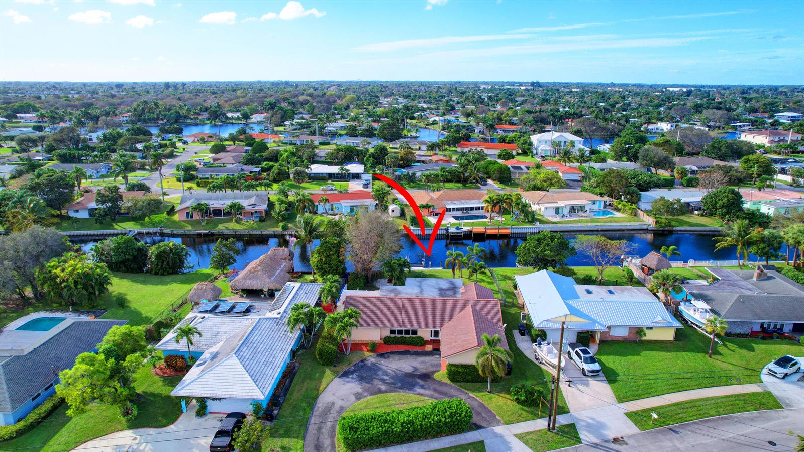 An aerial view shows a waterfront house with a dock, pool, and circular driveway — 1753 W Terrace Drive, FL 33460, FL