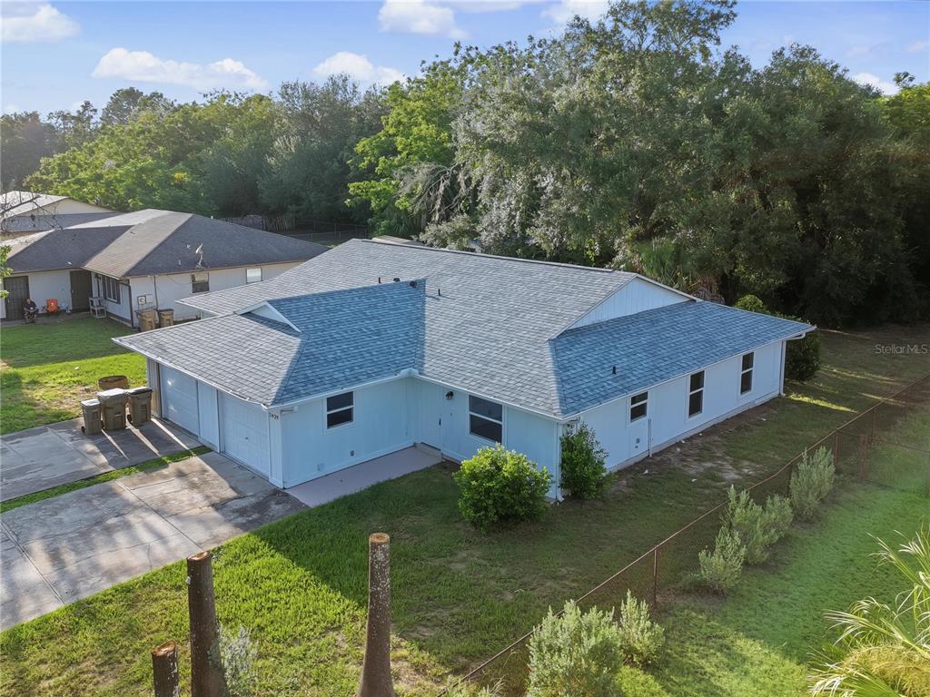 An aerial view of a light blue house with a gray shingled roof and driveway — 2429 CENTENNIAL BOULEVARD, LEESBURG, FL