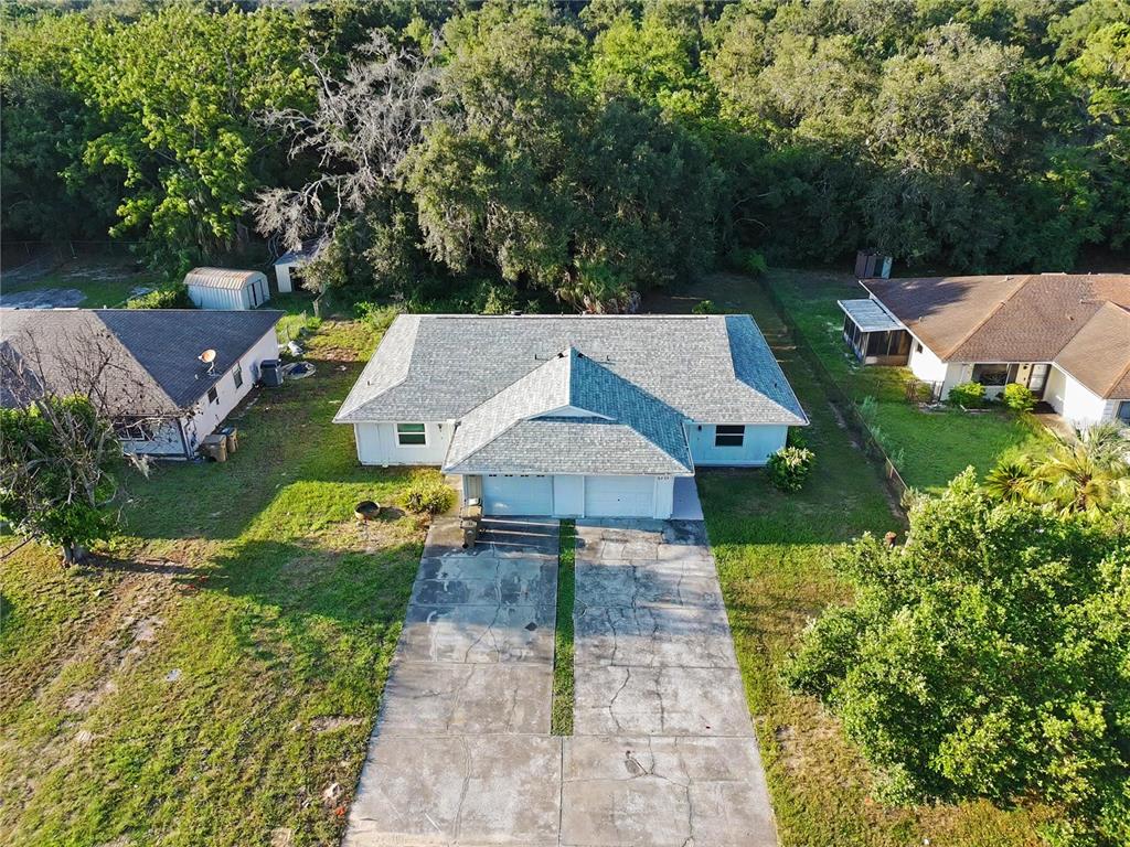 An aerial view shows a single-story house with a two-car garage and a concrete driveway — 2429 CENTENNIAL BOULEVARD, LEESBURG, FL