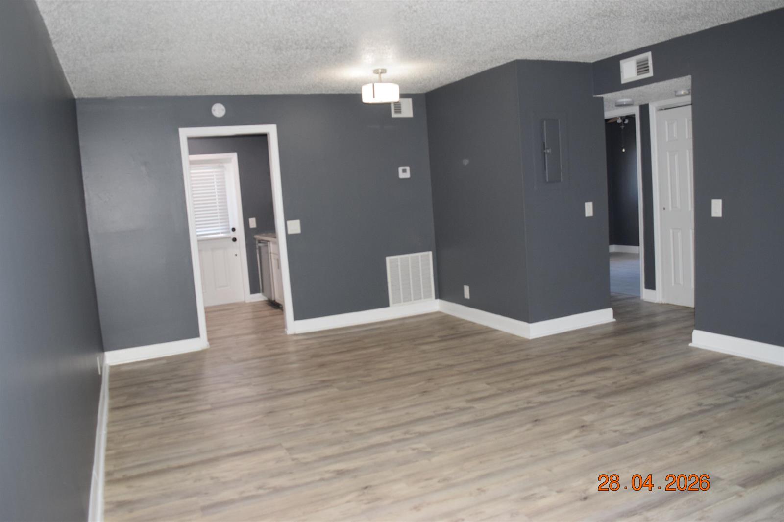 An empty room features dark gray walls, light wood-look flooring, and white trim — 3166 Melaleuca Road, West Palm Beach FL 33406, WEST PALM BEACH, FL