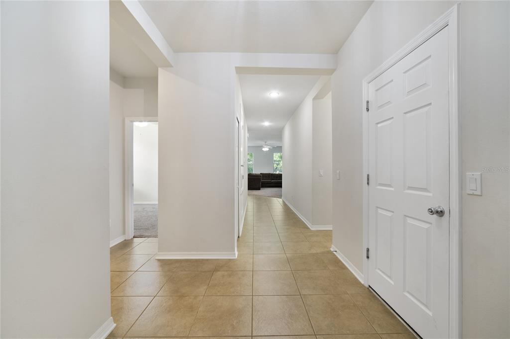 A tiled entryway leads into a hallway with white walls and a closed white door — 3773 MOON DANCER PLACE, ST CLOUD, FL