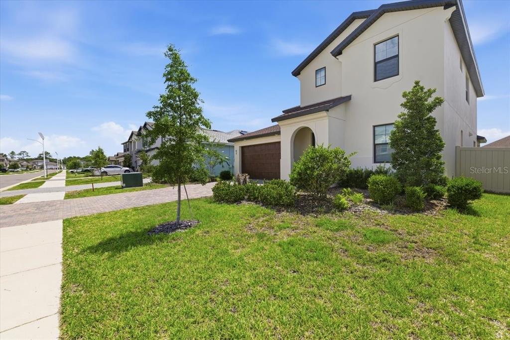 A two-story house with a brown garage door and a paved driveway under a blue sky — 82 HILLSHIRE PLACE, SPRING HILL, FL