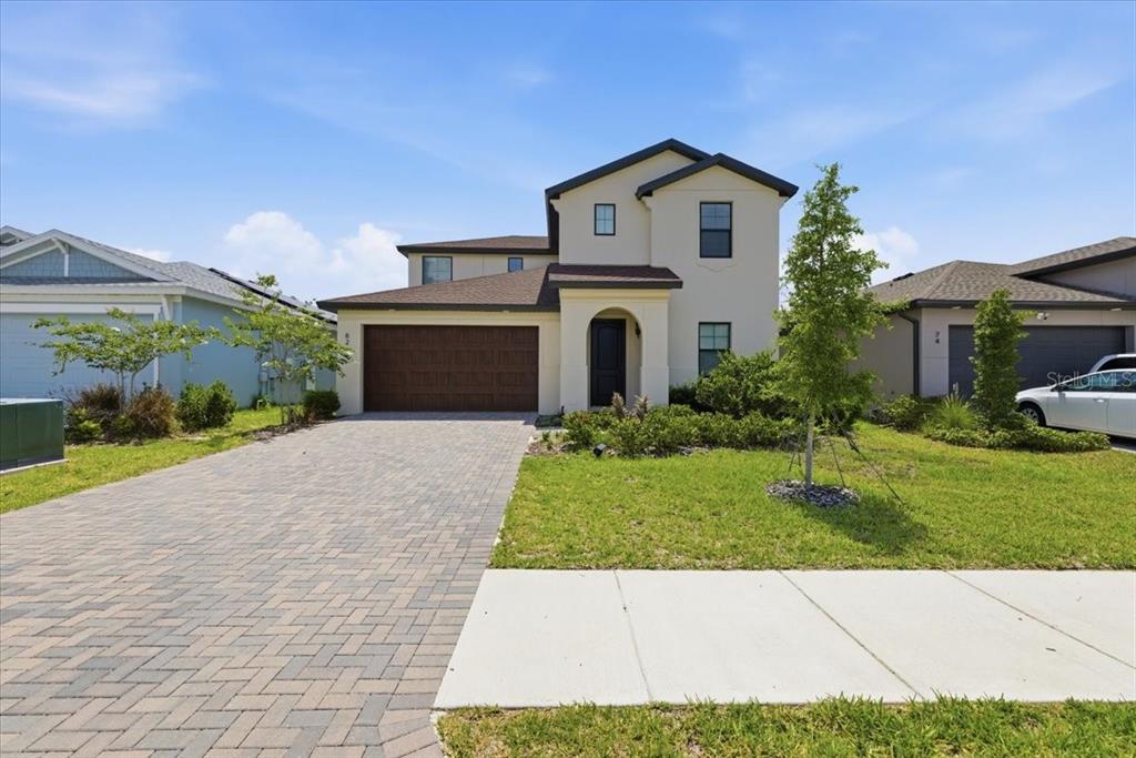 A two-story suburban house with a paved driveway, a two-car garage, and a front lawn — 82 HILLSHIRE PLACE, SPRING HILL, FL