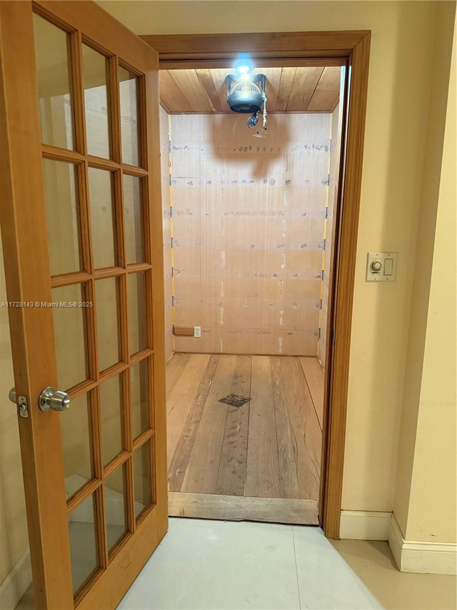 An unfinished walk-in closet features wood-paneled walls, a wood floor, and a ceiling-mounted light fixture — 777 NW 72nd Ave # 2131, Miami FL 33126, MIAMI, FL