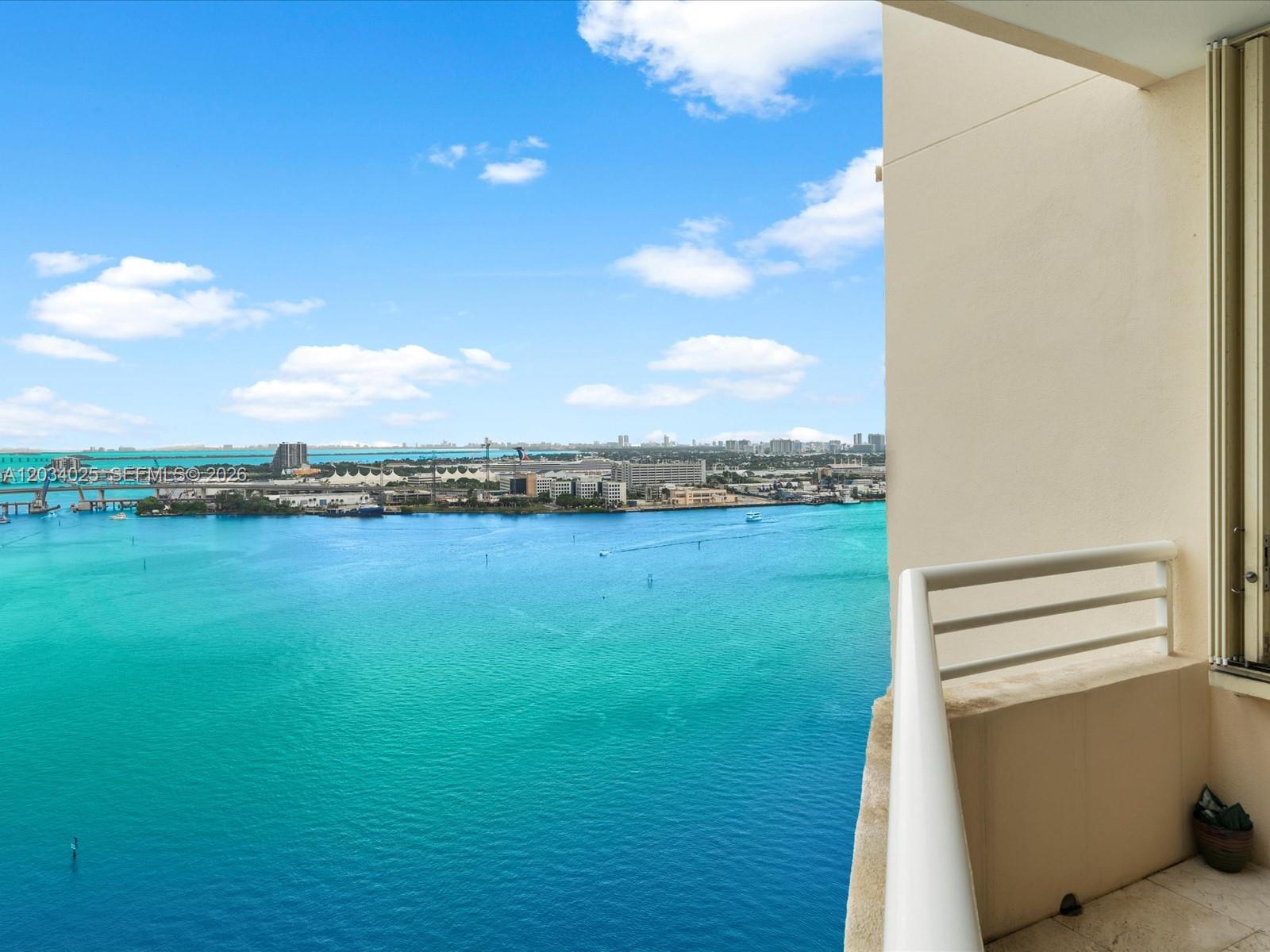 A balcony overlooks a wide turquoise bay with a distant city skyline and cruise ships — 888 Brickell Key Dr # 2510, Miami FL 33131, MIAMI, FL
