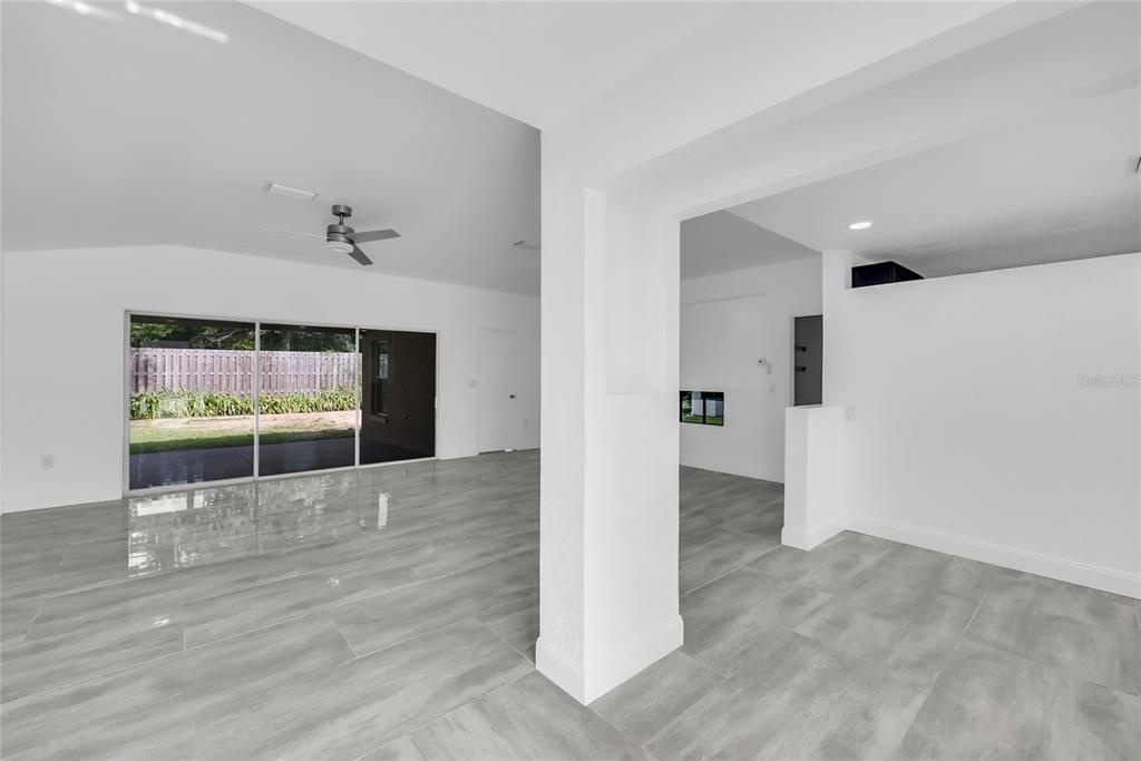 An interior view of a room with light gray tile flooring and sliding glass doors — 9119 SE 120TH LOOP, SUMMERFIELD, FL