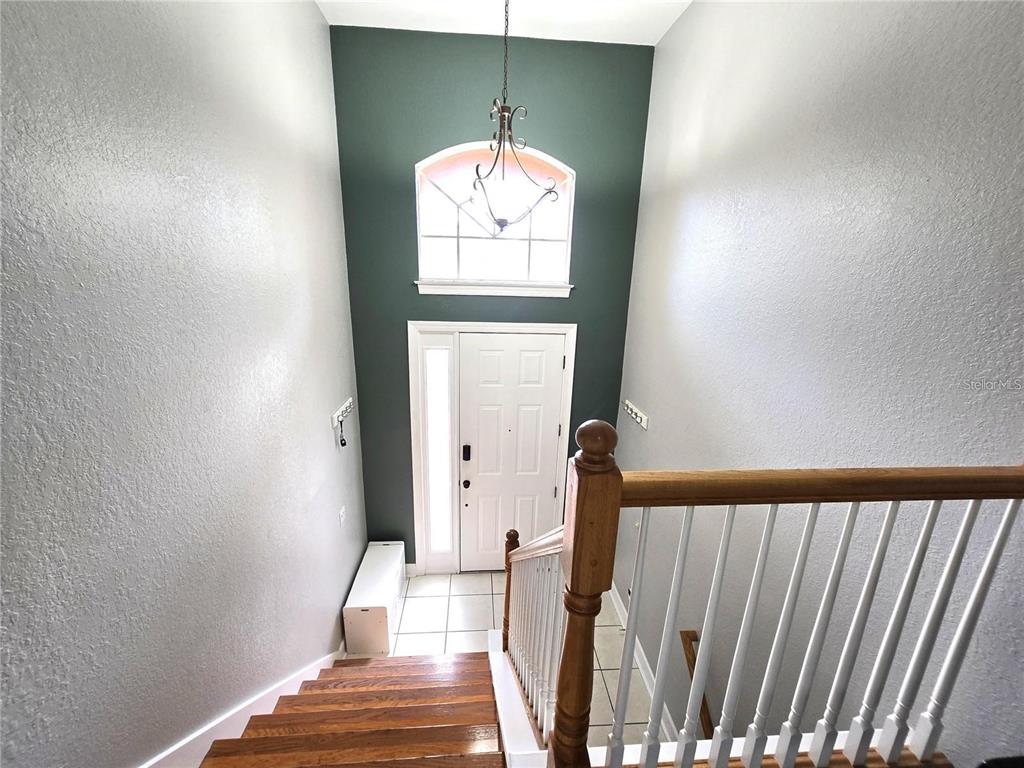 A view from a staircase looking down at a front entryway with a dark accent wall — 5429 46TH COURT W, BRADENTON, FL