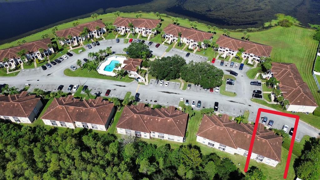 An aerial view shows a residential apartment complex with a swimming pool and parking lot — 13801 TIMBERLAND DRIVE UNIT 201, ORLANDO, FL