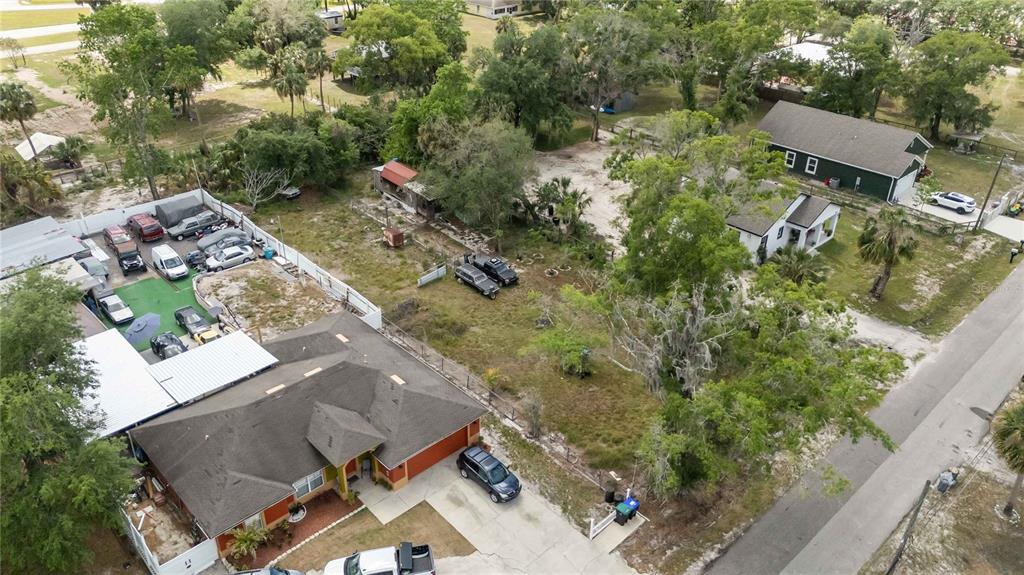 An aerial view shows a residential property with a house, a large yard, and vehicles — 0 3RD AVENUE, ORLANDO, FL