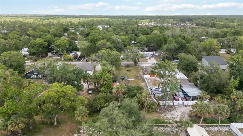An aerial view shows several houses, trees, and a fenced lot in a residential area — 0 3RD AVENUE, ORLANDO, FL