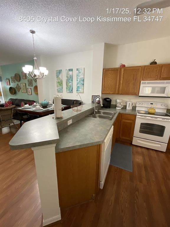 A kitchen features wood cabinets, a gray countertop, and a breakfast bar overlooking a dining area — 8405 CRYSTAL COVE LOOP, KISSIMMEE, FL