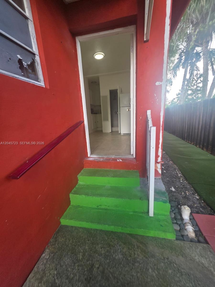 A bright red exterior wall features green steps leading to an open doorway into a kitchen — 10861 NW 22nd Ct # 0, Miami FL 33167, MIAMI, FL