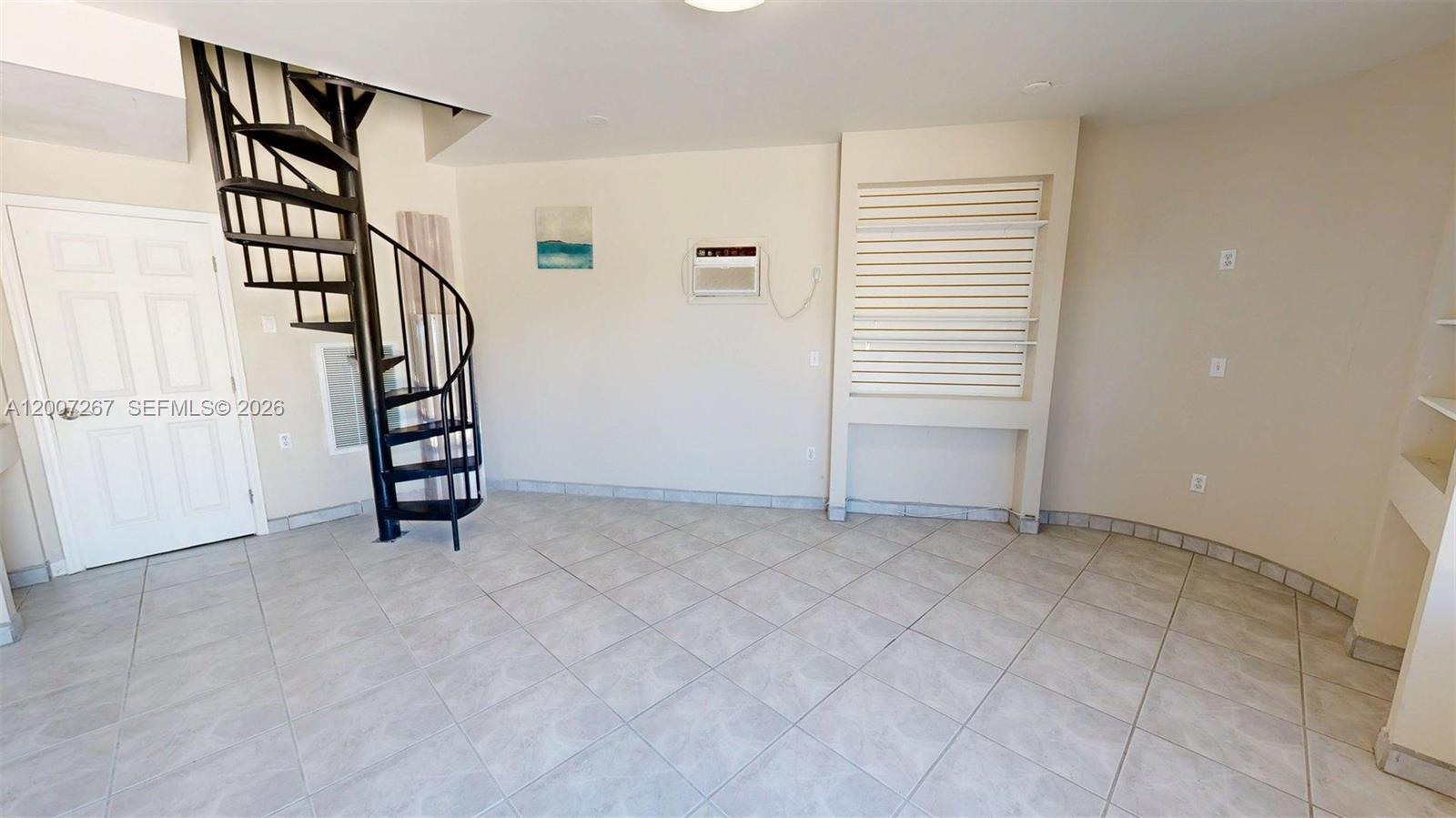 A room with tile flooring, a black spiral staircase, and a built-in shelving unit — 103301 Overseas Hwy, Key Largo FL 33037, KEY LARGO, FL