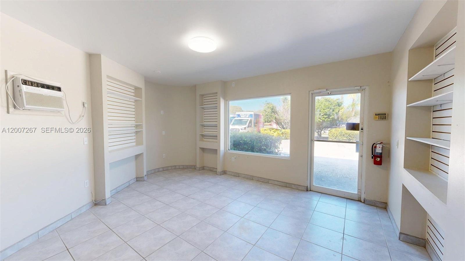 A commercial room features tiled floors, built-in shelving, a window, and a glass entry door — 103301 Overseas Hwy, Key Largo FL 33037, KEY LARGO, FL