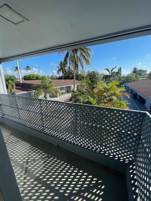 A balcony with a white lattice railing overlooks a tropical residential complex with palm trees — 1711 S Cypress Road, Pompano Beach FL 33060, POMPANO BEACH, FL