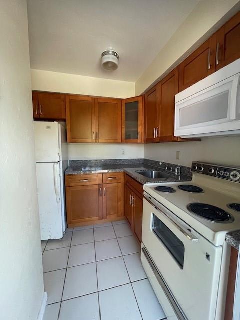 A kitchen with wood cabinets, white appliances, and white tile flooring — 1711 S Cypress Road, Pompano Beach FL 33060, POMPANO BEACH, FL