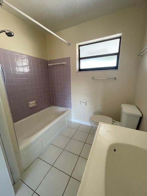 A bathroom features a purple-tiled shower-tub combo, a white toilet, and a vanity sink — 1711 S Cypress Road, Pompano Beach FL 33060, POMPANO BEACH, FL