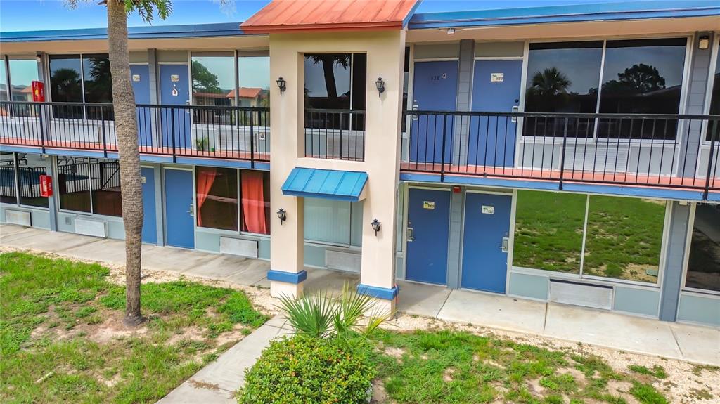 An exterior view of a two-story motel building with blue doors and metal railings — 43420 HIGHWAY 27 UNIT 320, DAVENPORT, FL